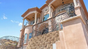 Un immeuble à plusieurs étages, doté d’une façade en pierre, de balcons en métal ouvragé et de grandes fenêtres.