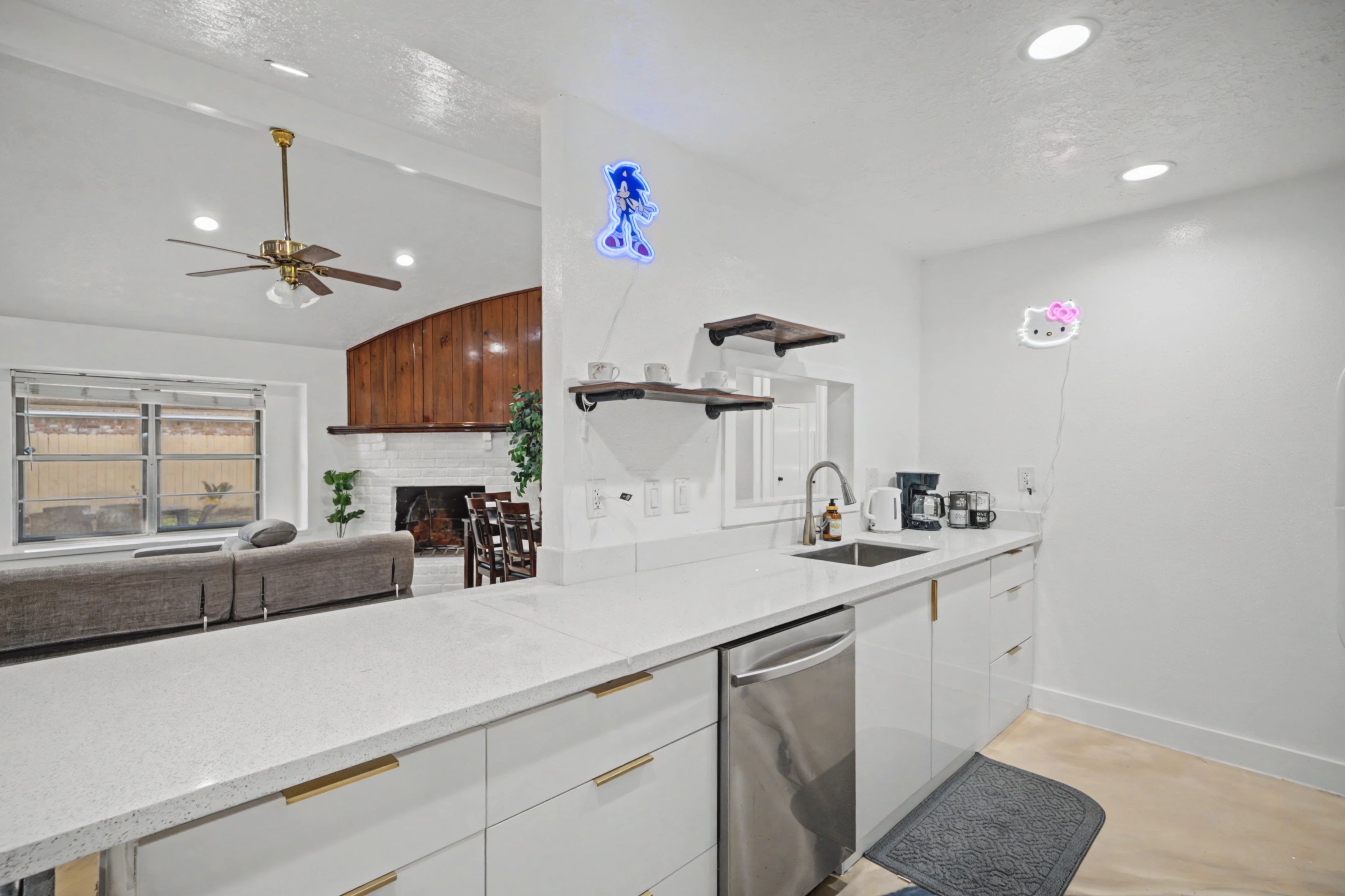 A modern kitchen with a central island, built-in appliances, and a ceiling fan.
