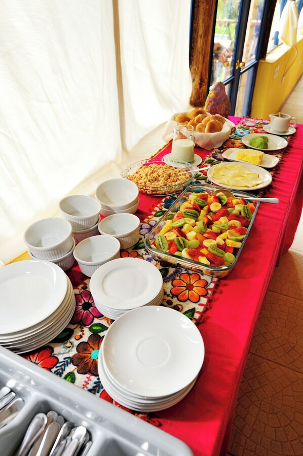 A buffet table with various food items and serving dishes. - Melissa Wasi (Písac)