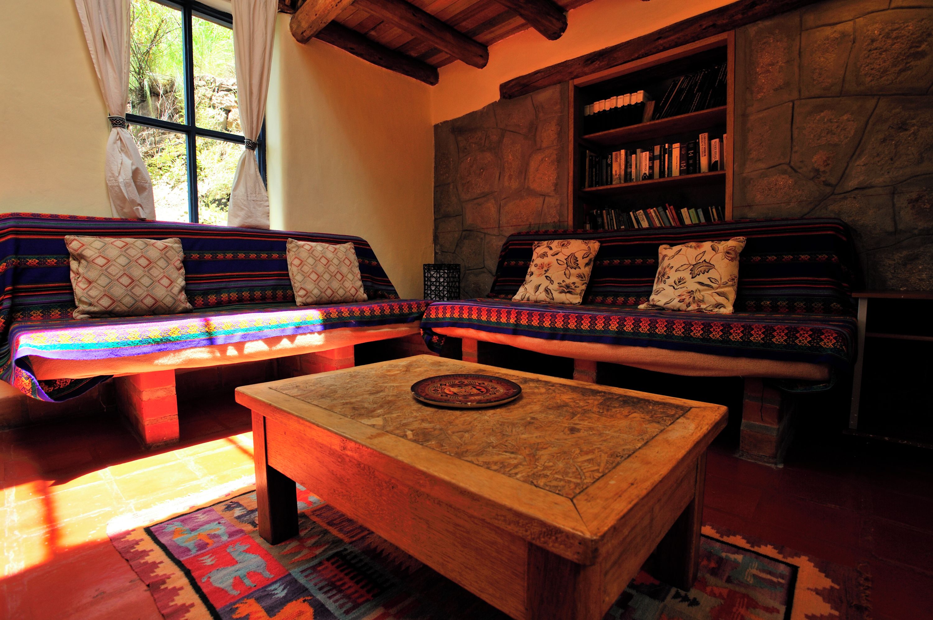 A cozy living room with two sofas, a coffee table, and a bookshelf.