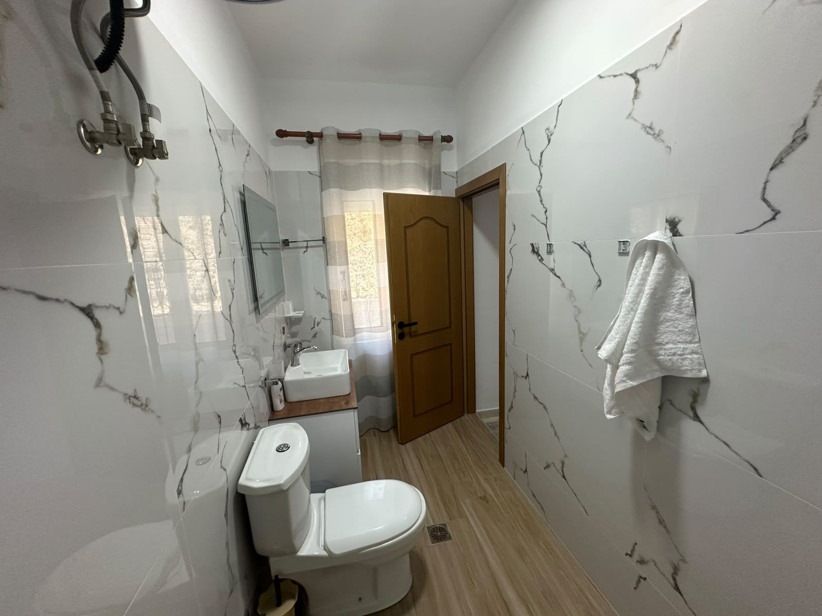 Une salle de bain comprenant des toilettes, un lavabo et un espace douche.