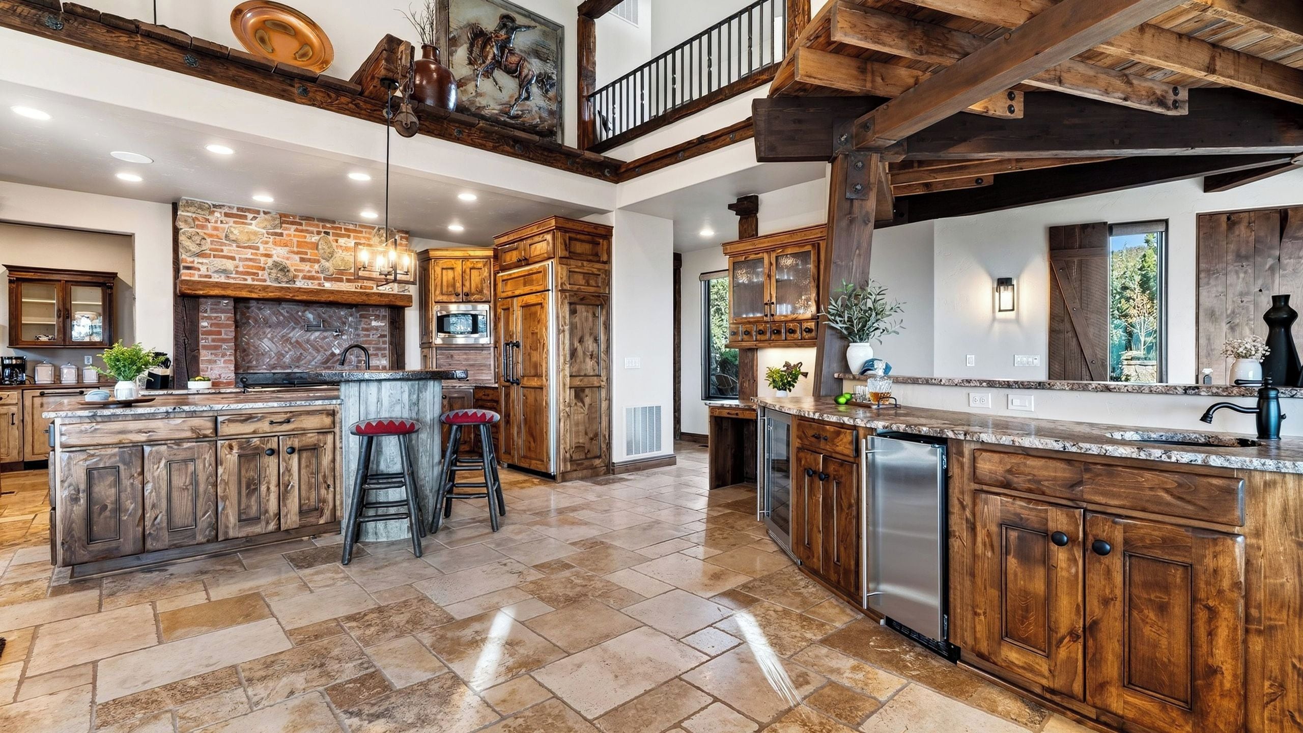 A spacious kitchen with a large island, wooden cabinetry, and a stone backsplash.