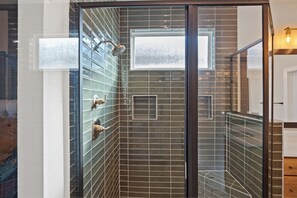 A shower with a glass door, a window, and a towel rack. - 3 BDRM East Austin Home - Mins to Downtown (Austin)