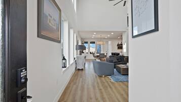 Ein geräumiger Flur mit Essbereich und Wohnzimmer, ausgestattet mit moderner Möbel und Kunstwerken.