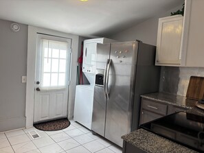 A compact kitchen with a stainless steel refrigerator, a built-in oven, and a granite countertop. - 1 mile to Bryant Denny Stadium (Tuscaloosa)