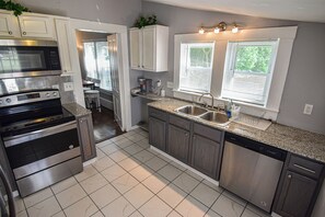 A modern kitchen with stainless steel appliances, a granite countertop, and a dishwasher. - 1 mile to Bryant Denny Stadium (Tuscaloosa)