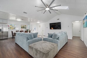 A modern living room with a sectional sofa, a coffee table, and a ceiling fan. - Bellaire Spacious 4 Br Home - sleep comfortably for 12 people + (Houston)