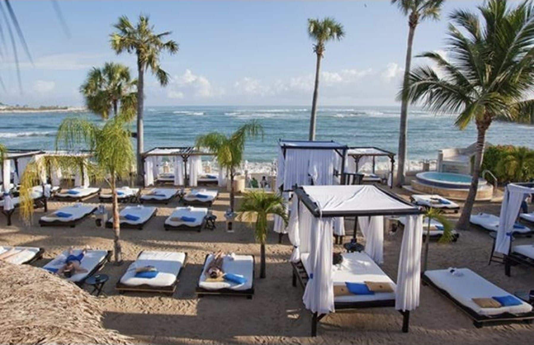 A beachside resort with multiple sunbeds and a pool area.