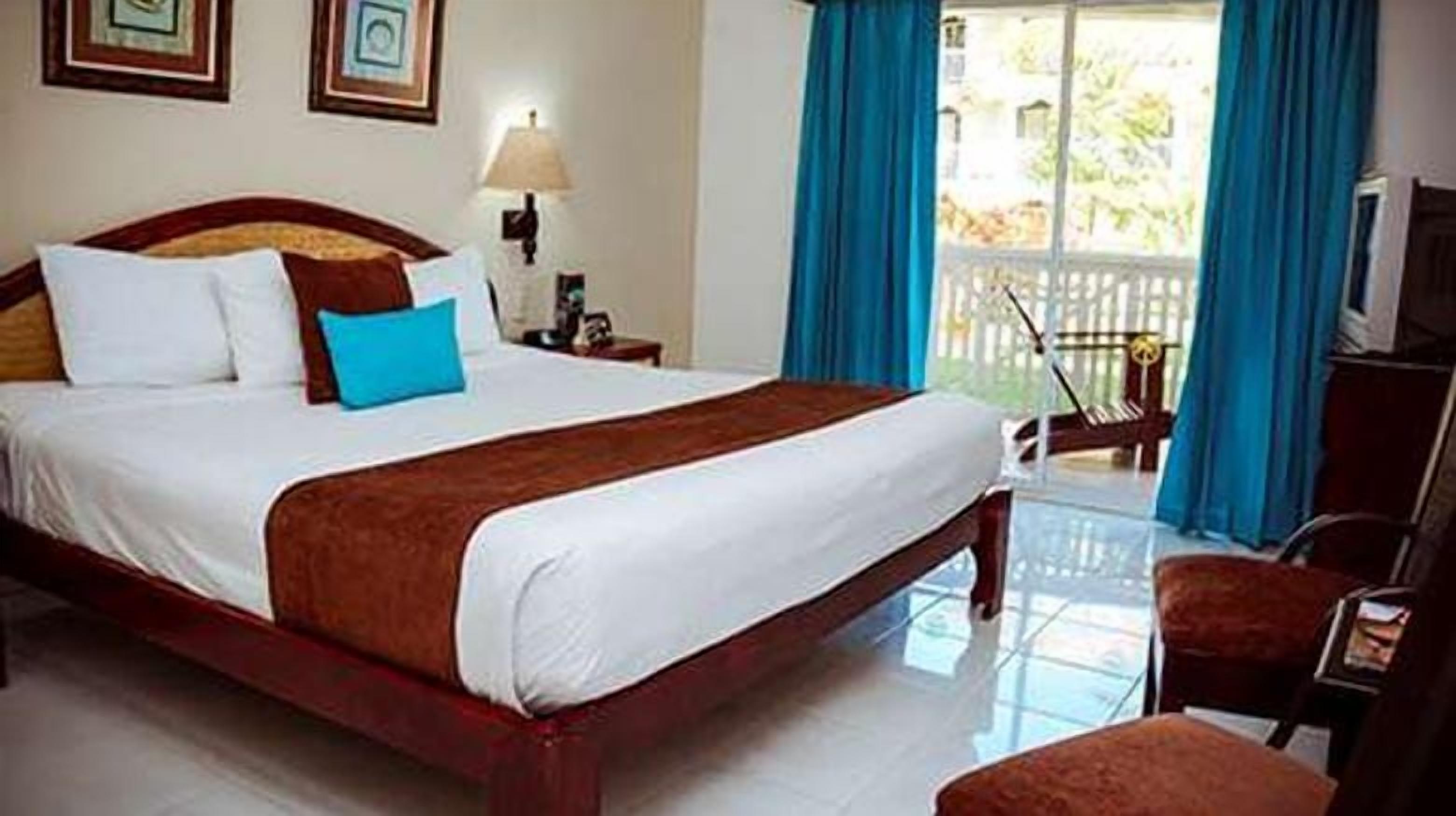 Una habitación de hotel con una cama grande, un escritorio y una silla.