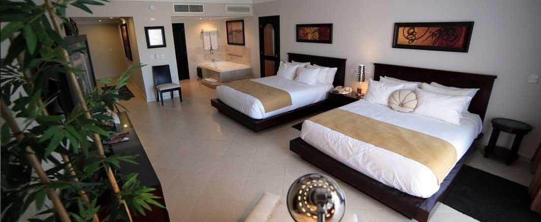 Ein Hotelzimmer mit zwei Betten, einem Essbereich und einer Wohnlounge.