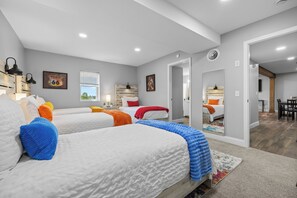A modern bedroom with three beds, a large mirror, and a view of the outdoors. - 12-Acre Nashville Retreat - Sleeps 12 - Game Room (Goodlettsville)
