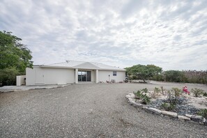 A single-story building with a flat roof, a front door, and a small porch area. - Harbour Rock Villa – Oceanview Hilltop Villa (PROVIDENCIALES)