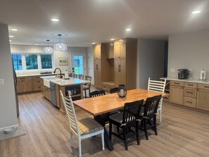 Une cuisine moderne avec des meubles en bois, un îlot central et un coin repas avec des chaises.