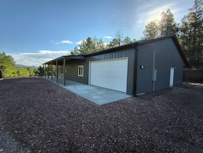 En enplansbyggnad med en inglasad veranda, ett garage och en grusuppfart.