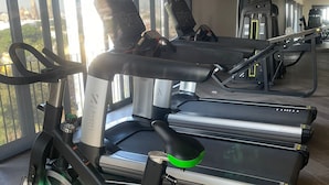 A gym with treadmills, exercise bikes, and a large window with a view of a cityscape. - Suite King en el Centro Guadalajara (Guadalajara)