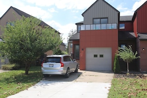 A residential area with houses, a driveway, and a parked SUV. - Great townhouse in Athens, 3 bedrooms, 5 beds, garage, Wi-Fi, bike path (Athens)