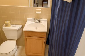Ein kleines Badezimmer mit Toilette, Waschbecken und Schrank.