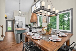 A modern kitchen with a dining area set for six. - Modern Farmhouse w Game Room Near Asheville! (Fairview)