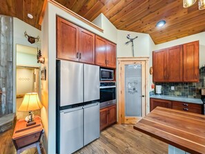 A kitchen with wooden cabinets, stainless steel appliances, and a wooden countertop. - Cozy Donnelly Retreat Near Boulder Creek | Wood Stove & Garage (Donnelly)