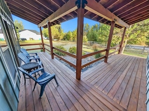 A wooden deck with a pergola, outdoor seating, and a view of a residential area. - Cozy Donnelly Retreat Near Boulder Creek | Wood Stove & Garage (Donnelly)
