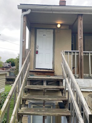 A wooden staircase leading to a white door with the number 407 D.
