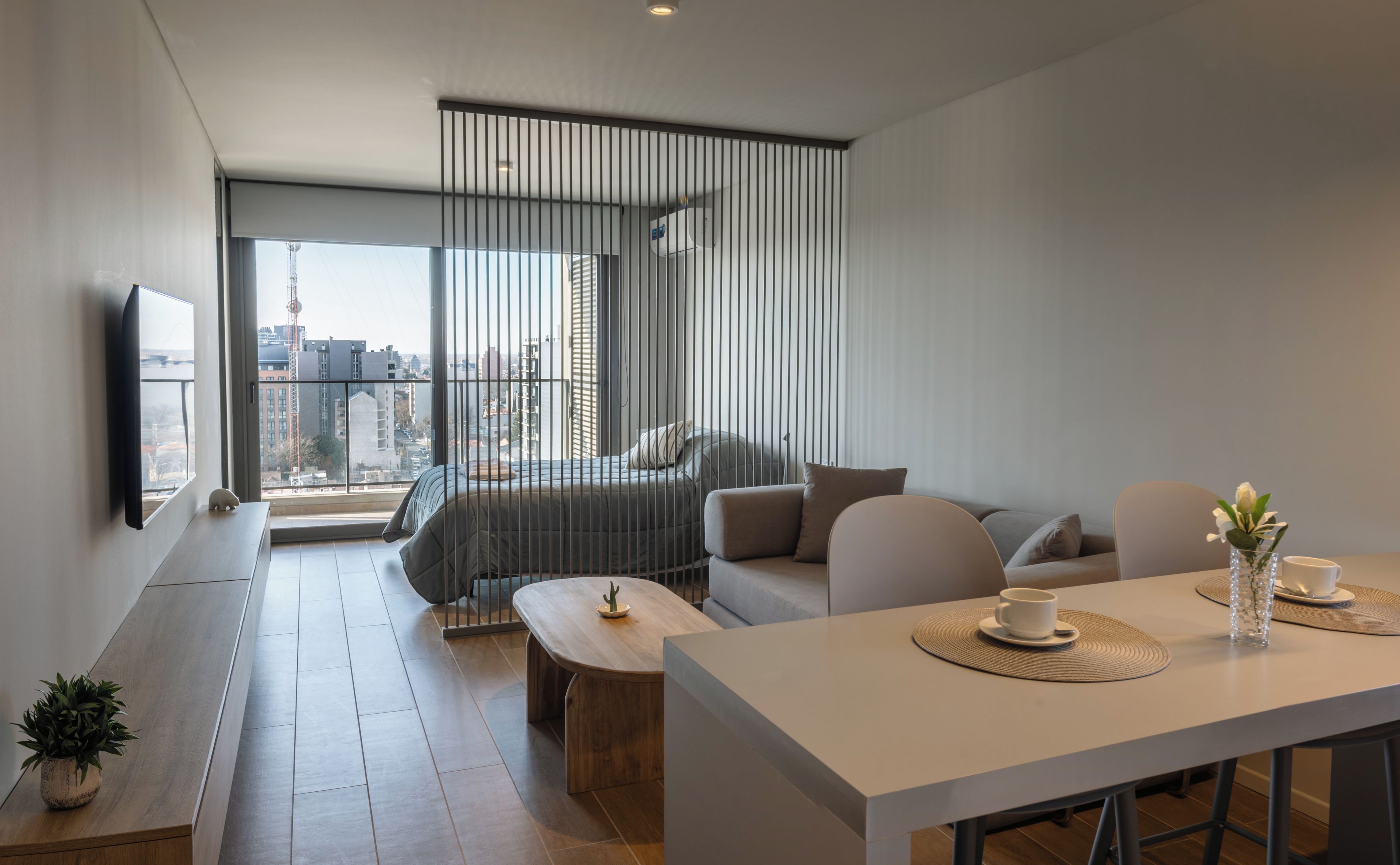 Una sala moderna con un sofá, una mesa de centro y un comedor con una mesa y sillas.