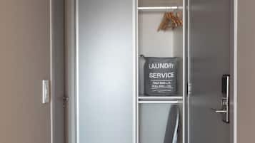 Un interior moderno con una puerta corredera que da a un área de lavandería, incluyendo un cartel con precios para bolsas pequeñas y grandes.