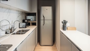 Una cocina moderna con electrodomésticos de acero inoxidable, horno empotrado y microondas.