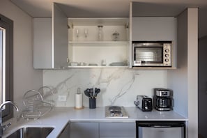 Una cocina moderna con microondas integrado, cafetera y tostadora.