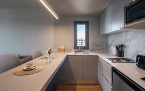 Una cocina moderna con lavavajillas incorporado, ventana con vistas y comedor con mesa y sillas.