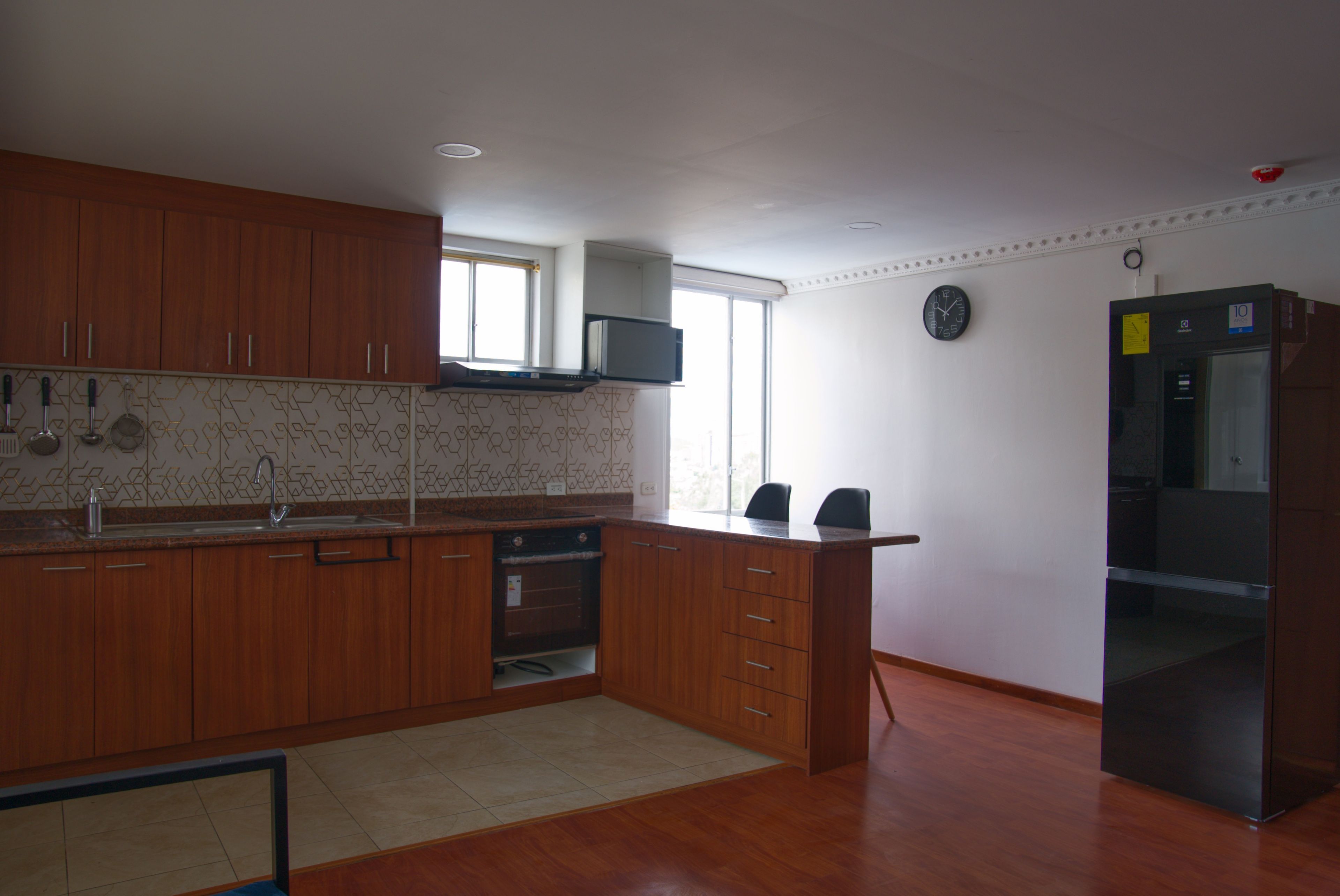Eine Küche mit Holzausstattung, einem Backofen, einer Mikrowelle und einem Kühlschrank.