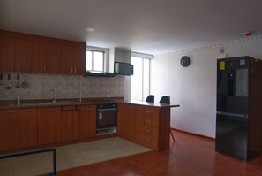 Eine Küche mit Holzausstattung, einem Backofen, einer Mikrowelle und einem Kühlschrank.
