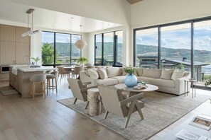 En moderne stue med en stor sofa, et sofabord og et spiseområde.