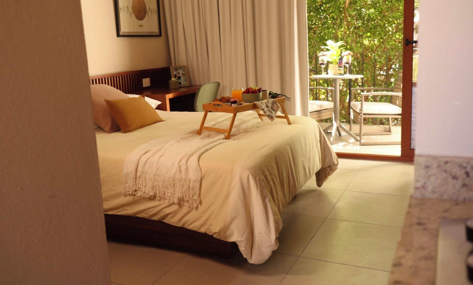 Une chambre d’hôtel avec un lit, un chariot de service pour le petit-déjeuner et une vue sur l’extérieur.