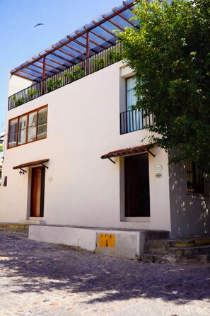 Un bâtiment à deux étages doté d’un balcon, d’une porte et d’une fenêtre.