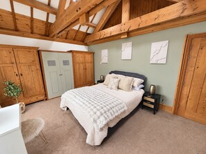 A bedroom with a bed, wooden wardrobe, and a desk. - Ty Cerrig Bach – Hot tub, games room & pet-friendly stay near Benllech (Tyn-y-Gongl)