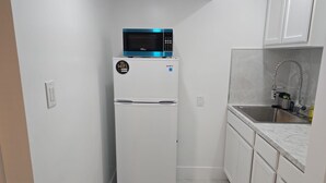 A compact kitchen with a white refrigerator, a microwave, and a sink. - Private King Suite with Private Entrance & Parking in Hialeah (Hialeah)