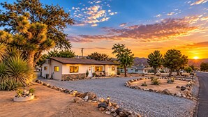 A residential area with houses, a gravel driveway, and a sunset. - Casa Sol, Fire Pit, Games, BBQ, Stargazing, More (Yucca Valley)