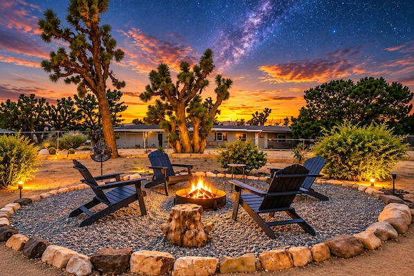 A nighttime outdoor seating area with a fire pit, chairs, and a view of the Milky Way. - Casa Sol, Fire Pit, Games, BBQ, Stargazing, More (Yucca Valley)