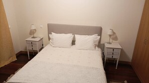 A bed with a headboard, two bedside tables, and two lamps. - City Center Boutique (Funchal)
