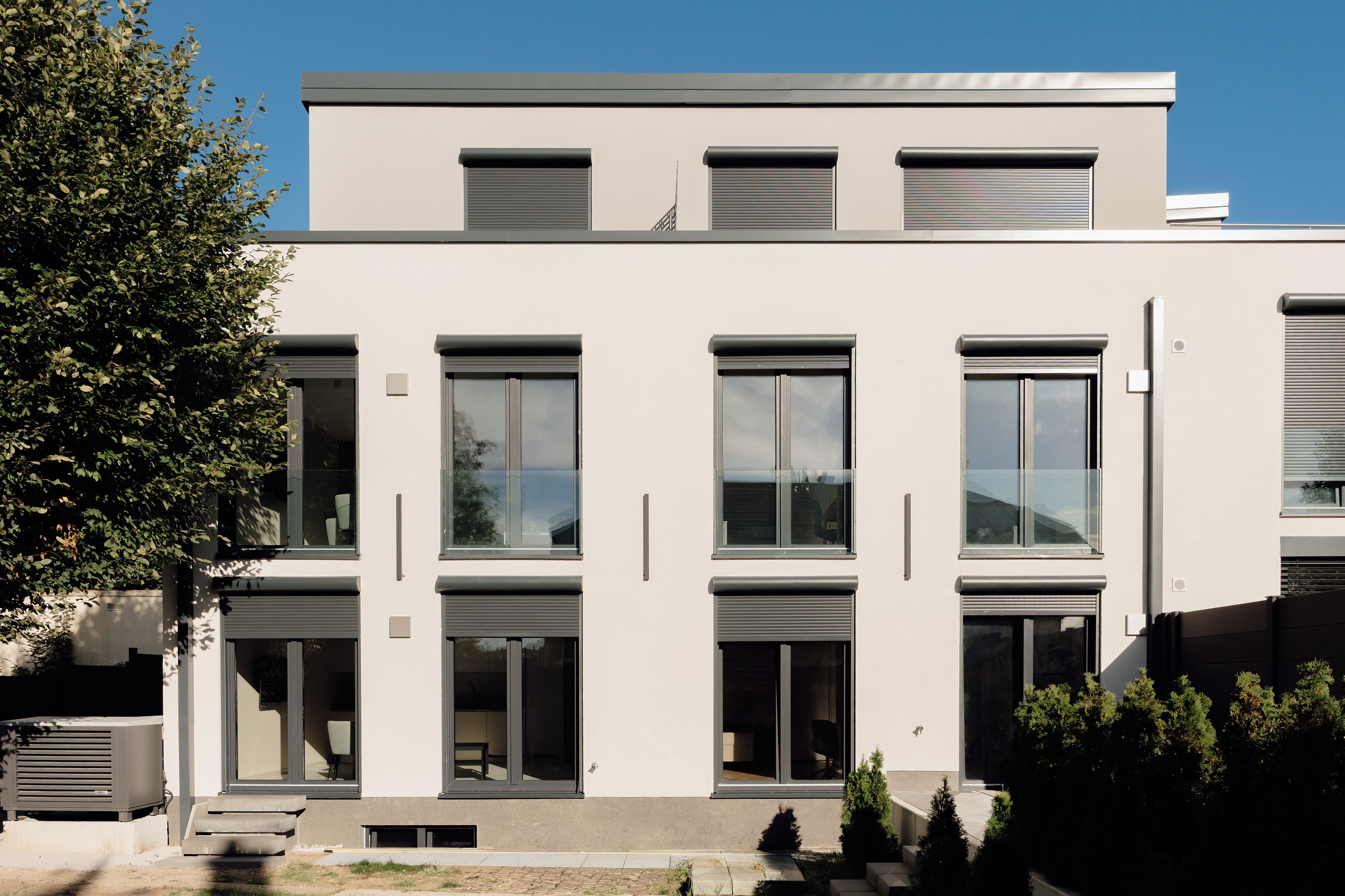 Un edificio moderno con diverse finestre e un tetto piatto.
