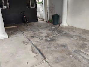 A concrete courtyard with a bicycle, a trash bin, and a metal rack. - Casa pame! (CHELEM)