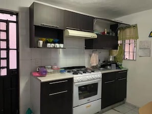 A kitchen with a gas stove, oven, and cabinets. - Casa pame! (CHELEM)