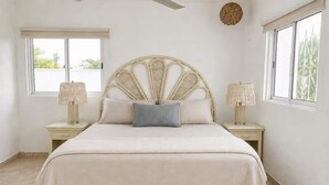 A bedroom with a bed, two bedside tables, a ceiling fan, and a window. - Peaceful 1-bedroom house in charming Chelem perfect for relaxing stays (CHELEM)