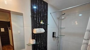 A bathroom with a white sink, toilet, and shower.