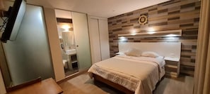 A hotel room with a bed, a wardrobe, a mirror, and a wall-mounted clock. - EL FARO HOTEL (Chala)