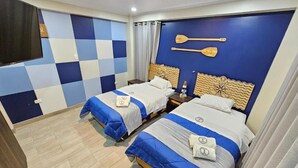 A hotel room with two beds, a checkered wall, and a wooden headboard with paddle designs.