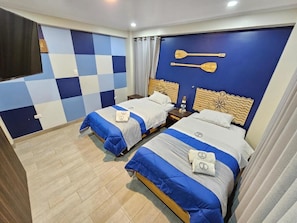 A hotel room with two beds, a checkered wall, and a wooden headboard with paddle designs. - EL FARO HOTEL (Chala)