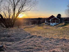 Un paysage rural avec une grange rouge et une tour à grain.