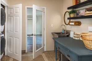 A laundry room with a washing machine, dryer, and open closet door leading to a hallway. - 7BR Family Retreat + Private Pond+ Outdoor Kitchen (Oregon City)